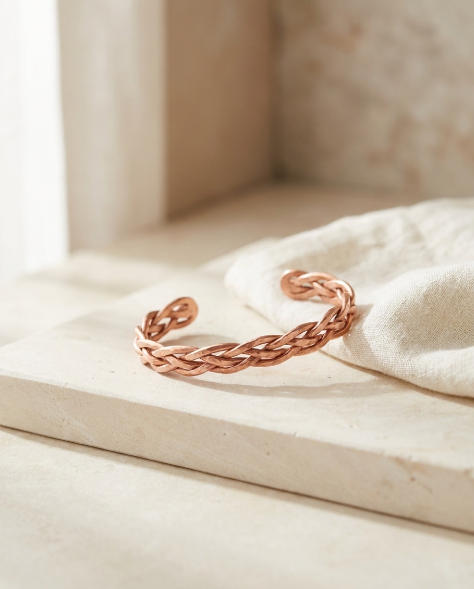 Handmade copper cuff resting on pale stone